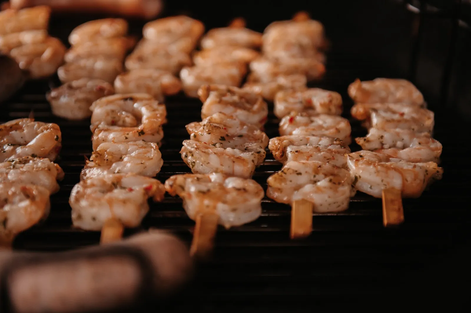 Kipspiesjes met kruidenmarinade grillen op het rooster van een houtskoolbarbecue